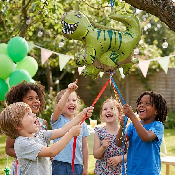 Kinder ziehen lachend an den Bändern einer Dino-Zugpinata am Kindergeburtstag